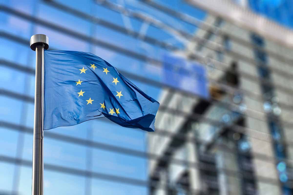 European Commission building with EU flag, symbolizing crypto regulation and stablecoin rules under MiCA